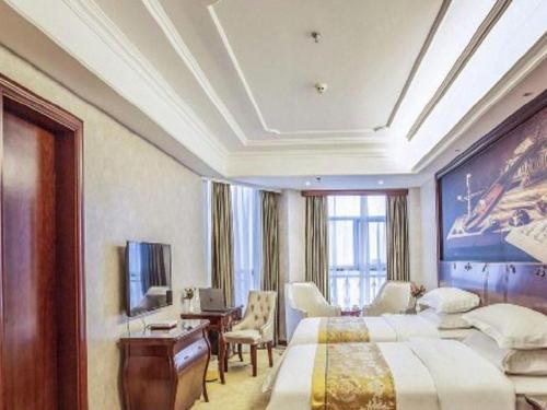 a hotel room with two beds and a desk at Vienna Hotel Guiyang Jiaxiulou Jichang Road in Guiyang
