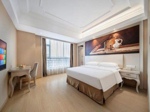 a hotel room with a bed and a table and a desk at Vienna Hotel Guiyang Jiaxiulou Jichang Road in Guiyang