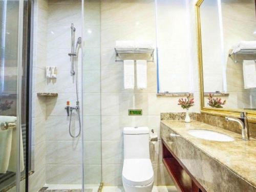 a bathroom with a shower and a toilet and a sink at Vienna Hotel Guiyang Jiaxiulou Jichang Road in Guiyang