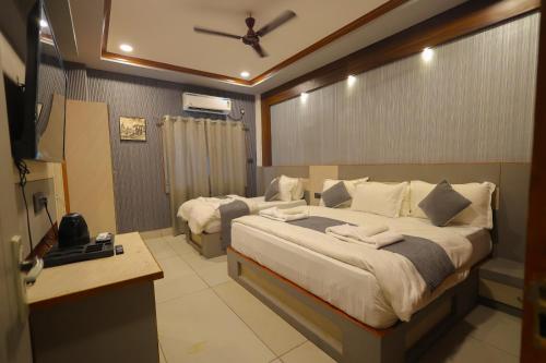 a bedroom with a large bed with a ceiling fan at Hotel Rohan Palace in Vrindāvan