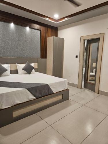 a bedroom with a large bed and a mirror at Hotel Rohan Palace in Vrindāvan