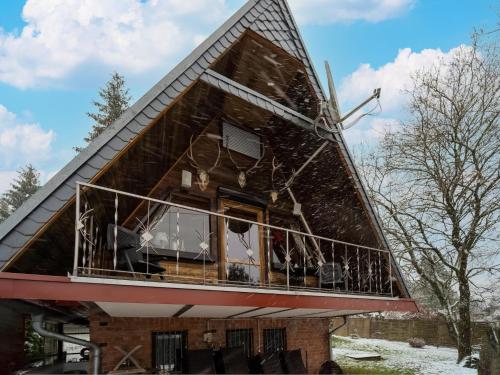 a house with a large window on the side of it at Cozy Forest Hideaway in Suhl in Suhl