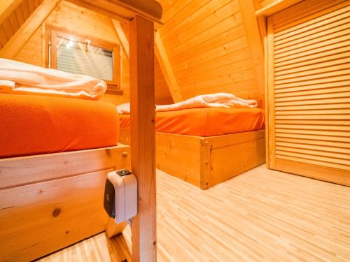 a room with two beds in a wooden cabin at Cozy Forest Hideaway in Suhl in Suhl