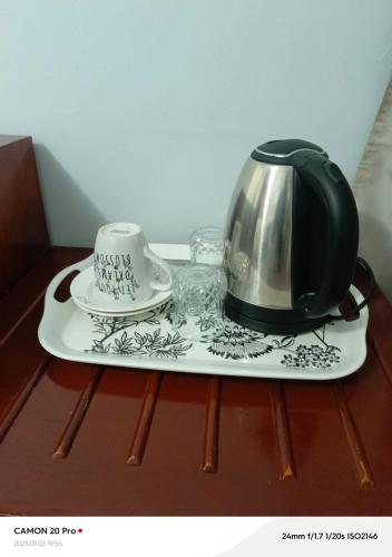 a tea kettle on a tray on a table at Raneziah Guesthouse in Kasane
