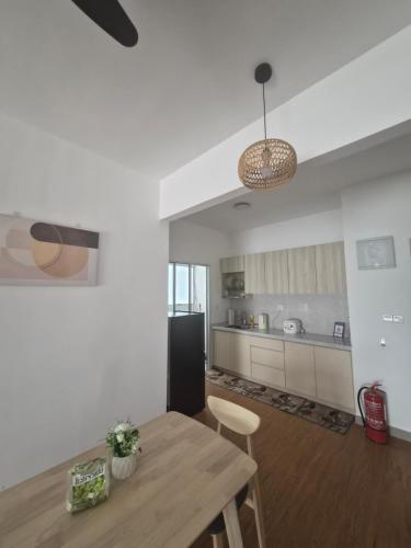 a kitchen with a wooden table and a dining room at Nine9 Homestay in Sepang