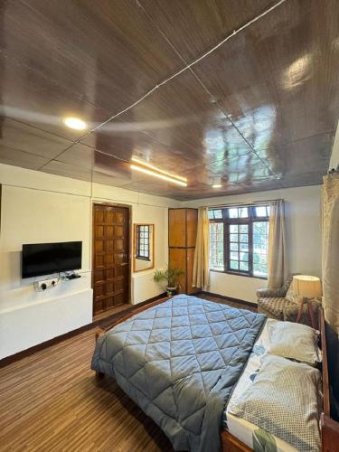 a bedroom with a large bed and a tv at BelleVue Home Stay in Shillong
