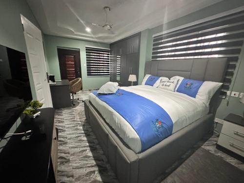a bedroom with a large bed with blue pillows at Arek Condos Accra in Sotuom