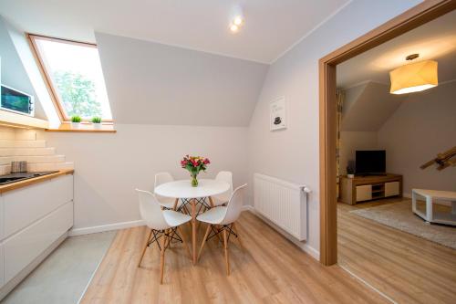 een keuken en eetkamer met een tafel en stoelen bij Apartamenty Pod Gubałówką in Zakopane