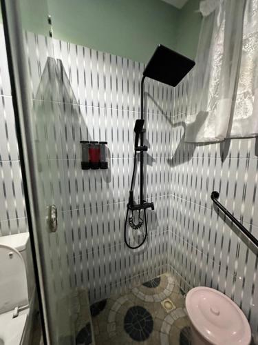 a bathroom with a shower with a toilet at Arek Condos Accra in Sotuom