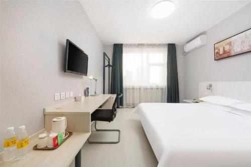 a hotel room with a bed and a desk with a sink at Jinjiang Inn Dalian Development Zone Jinma Road Light Railway Station in Jinzhou
