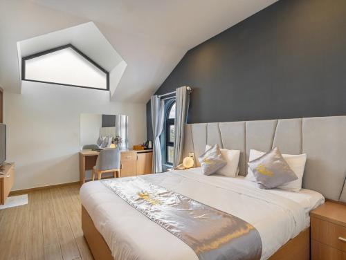 a bedroom with a large white bed with a window at Gold View Boutique Hotel Đà Lạt in Da Lat