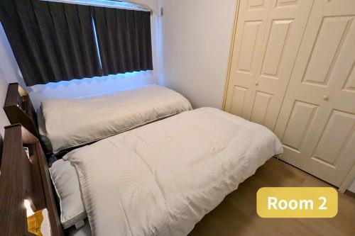 a bedroom with two beds and a door at Vacation House 2 in Funabashi