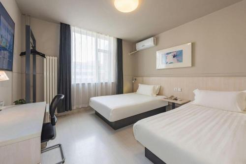 a hotel room with two beds and a window at Jinjiang Inn Beijing Huairou Qingchun Road Wanda Plaza in Beijing