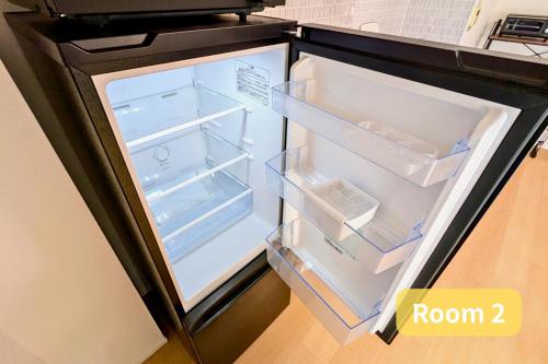 an open refrigerator with its door open in a kitchen at Vacation House 2 in Funabashi