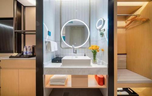 a bathroom with a sink and a mirror at Vienna Hotel Tianjin Guizhou Road Branch in Tianjin