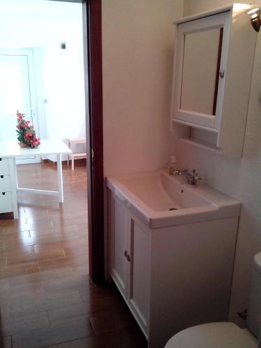 a bathroom with a sink and a mirror at Visitar Bioucas II - Casa Tradicional Familiar in Bioucas