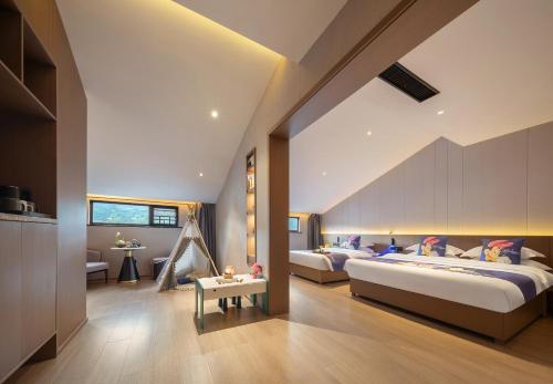a bedroom with two beds and a table at GUI YUAN ZHEN PIN HOTEL- Approximately 3 kilometers from the East Gate of Zhangjiajie National Forest Park - Free one-way pick-up or drop-off service for over 3 nights - English speaking customer service in Zhangjiajie