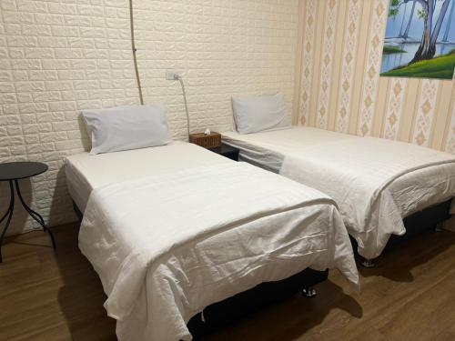 two beds sitting next to each other in a room at 水源棧 in Fengyuan