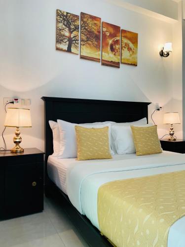 a bedroom with a bed with two lamps and two tables at 4 Axes Ella in Ella