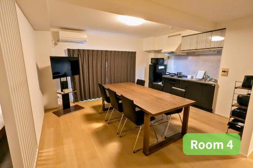 a room with a table and chairs and a kitchen at Vacation House 2 in Funabashi