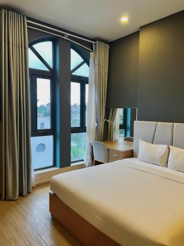 a bedroom with a large bed and a large window at Gold View Boutique Hotel Đà Lạt in Da Lat