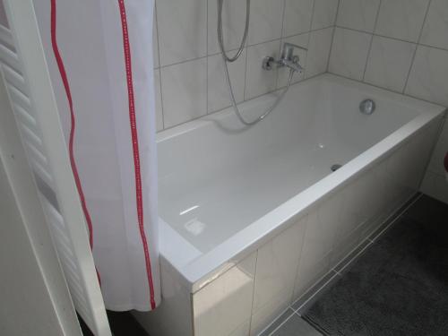 a white bath tub in a bathroom with a shower at KRIO Nicola Rothfuchs Ferienwohnung 2 in Idar-Oberstein