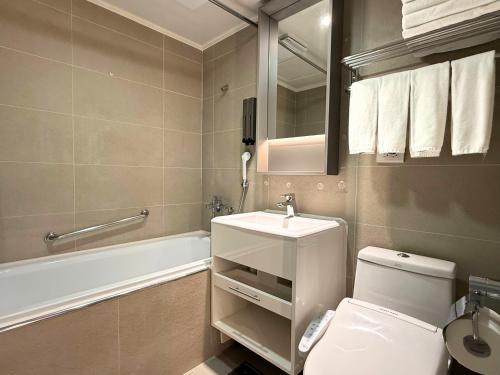 a bathroom with a toilet and a sink and a tub at Hub Hotel Ximen-inn Kunming in Taipei