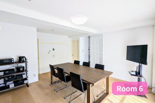 a dining room with a table and chairs and a flat screen tv at Vacation House 2 in Funabashi