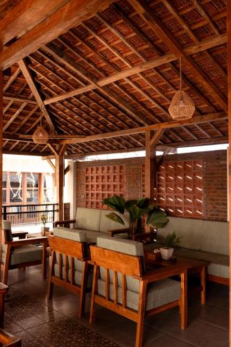 a living room with a table and chairs and a wooden ceiling at Puri Kaja House in Badung