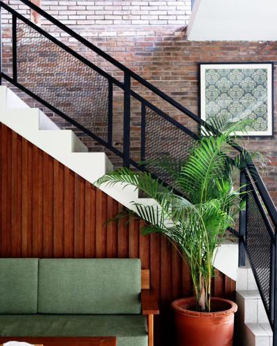 a staircase with a potted plant next to a brick wall at Puri Kaja House in Badung