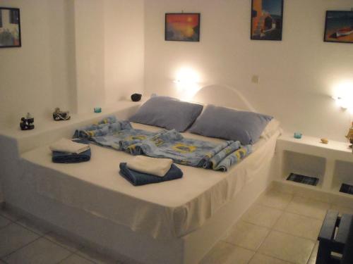 Una cama en una habitación con toallas. en Ostria Vento, en Pollonia