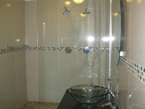 a bathroom with a shower with a glass door at Shirleys Place in Brackenfell