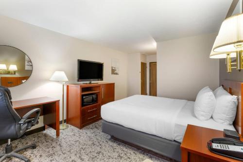 a hotel room with a bed and a desk and a television at Quality Inn & Suites Fillmore I-15 in Fillmore