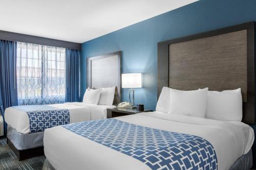 two beds in a hotel room with blue walls at Cielo Hotel Bishop-Mammoth, an Ascend Collection Hotel in Bishop