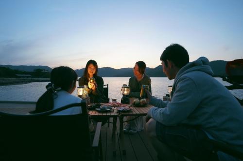 a group of people sitting around a table on the water at TADAYOI - Sea Glamping - Vacation STAY 42104v in Hishi