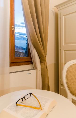 a pair of glasses sitting on a table in front of a window at Residenza Marchesi Pontenani in Florence