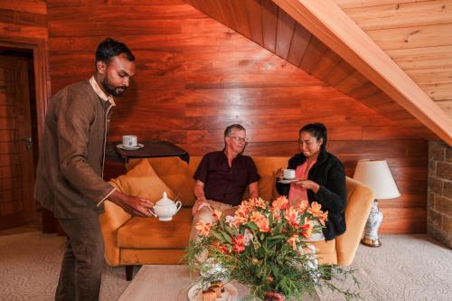 a group of three people sitting in a room at Baron Luxury Boutique in Nuwara Eliya