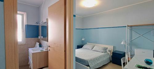 a small blue bedroom with a bed and a window at Guest House Roma Express in Ladispoli