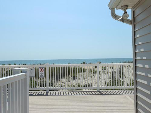 a deck with a fence and the ocean in the background at Ocean Front Condo Beach Haven, Pool Beach Badges Wifi Ocean Views in Beach Haven
