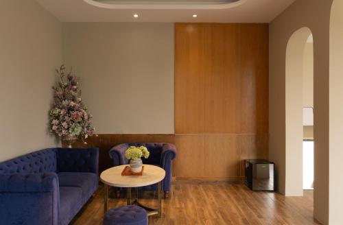 a living room with a blue couch and a table at Gold View Boutique Hotel Đà Lạt in Da Lat