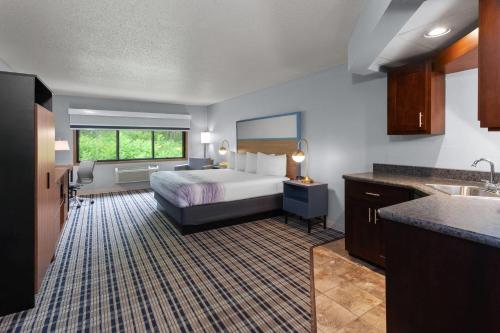 a hotel room with a bed and a sink at AmericInn by Wyndham West Salem in West Salem
