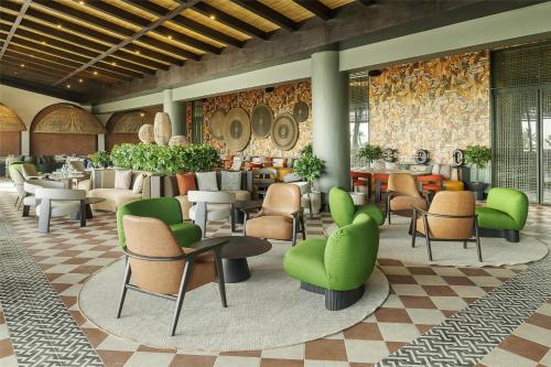 a lobby with green chairs and tables in a building at Zemi Miches Punta Cana All-Inclusive Resort, Curio by Hilton in Miches