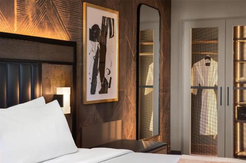 a bedroom with a bed and a mirror at Hotel Avail Rogers, Tapestry Collection By Hilton in Rogers