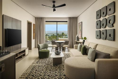 a living room with a couch and a tv at Zemi Miches Punta Cana All-Inclusive Resort, Curio by Hilton in Miches