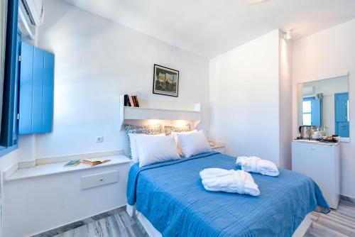 a bedroom with a blue bed with two towels on it at Sigalas Beach Hotel in Kamari