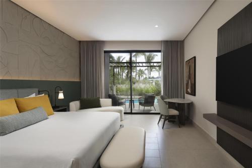 a hotel room with a bed and a table at Zemi Miches Punta Cana All-Inclusive Resort, Curio by Hilton in Miches