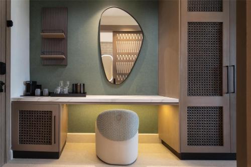 a dressing room with a mirror and a stool at Zemi Miches Punta Cana All-Inclusive Resort, Curio by Hilton in Miches