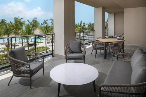 a balcony with chairs and tables and a view of the ocean at Zemi Miches Punta Cana All-Inclusive Resort, Curio by Hilton in Miches