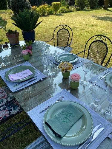 a table with plates and wine glasses on it at L’hirondelle du Faubourg in Saudemont