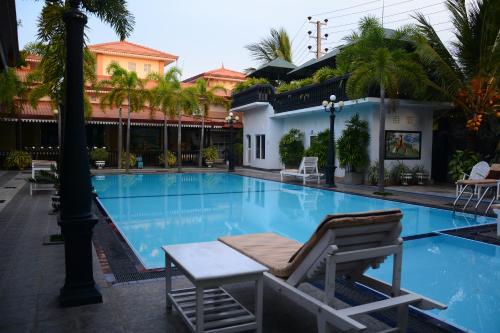 a pool at a hotel with a lounge chair next to it at JKAB Park Hotel in Trincomalee